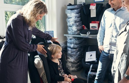 Pige prøver en autostol i en butik, som sælger autostole.