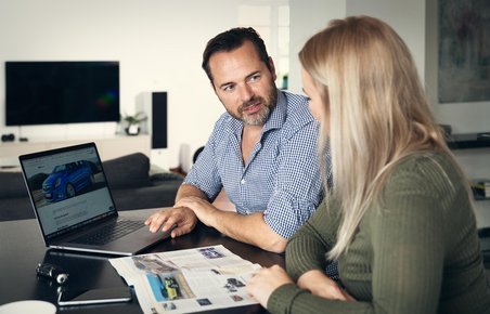Mand og kvinde overvejer, om de skal købe bil eller privatlease. 