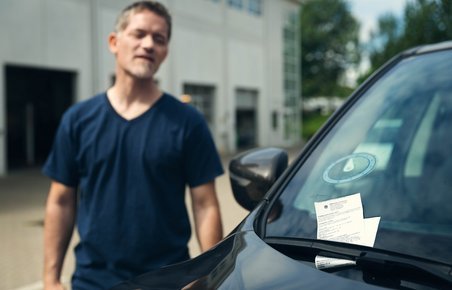 Mand opdager p-afgift på sin forrude. 