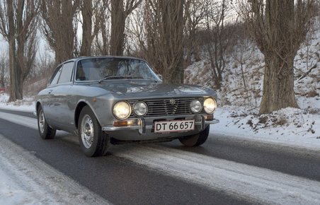 Foto af sølvfarvet Alfa Romeo i snevejr.