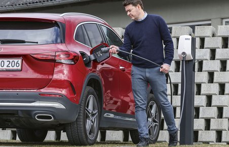 Mand gør klar til at oplade plugin-hybrid.