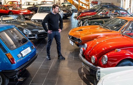 Mand i hal fyldt med klassiske biler
