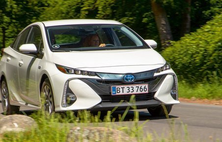 Kvinde kører i hybridbil. 