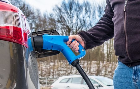 Mand ved dc-lader bil i koldt vejr