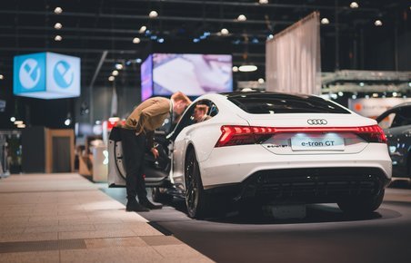 Mand kigger ind i udstillet Audi e-tron GT på elbilmessen eCarExpo.