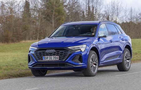 Elbilen Audi Q8 kører på landevej med græs i baggrunden