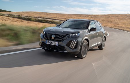 En Peugeot E-2008 kører i et sving på en landevej i høj fart