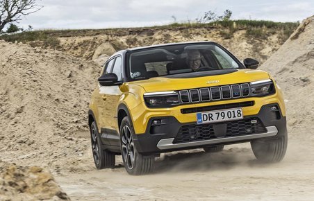 Gul Jeep Avenger kører på en grusvej
