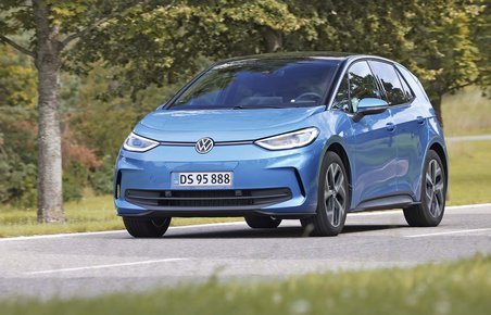 Elbilen VW ID.3 kører på en landevej med træer i baggrunden.
