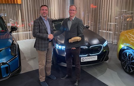 BMW i5 med to personer i forgrunden.