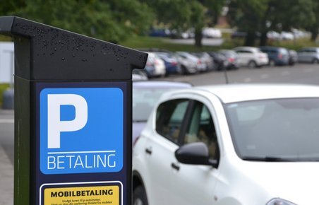 Bil kører forbi parkeringsautomat