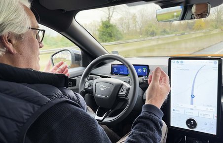 Fører sidder bag rattet uden hænder på rattet, mens bilen kører på motorvej.