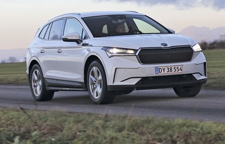 En Skoda Enyaq elbil set forfra kører i tusmørke på en landevej