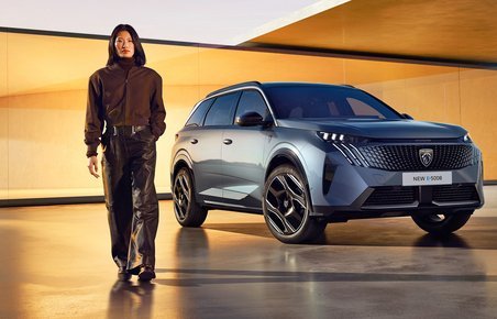 Peugeot 5008 forfra med person i forgrunden.