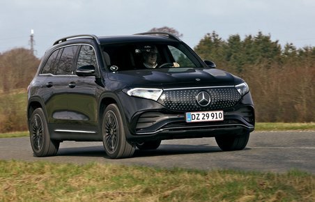 Sort Mercedes EQB kører på en landevej med træer i baggrunden