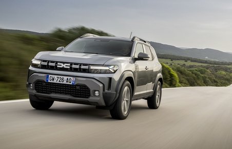 Dacia Duster set forfra kører på lang, lige landevej.