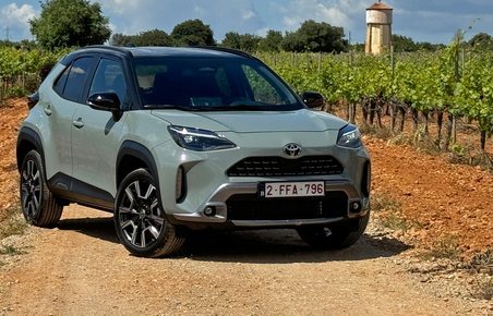 Toyota Yaris Cross holder på en grusvej med vinmarker rundt om