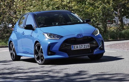 Blå Toyota Yaris kører i rundkørsel