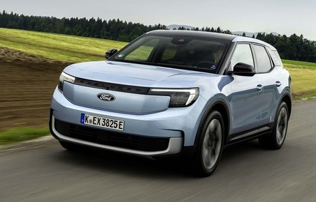 Sølvgrå Ford Explorer kører på vej med marker i baggrunden