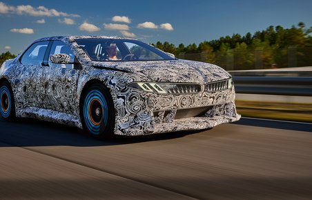 Kamufleret BMW i høj fart på testbane.