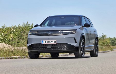 Opel Grandland kører i sving på vej med blå himmel i baggrunden